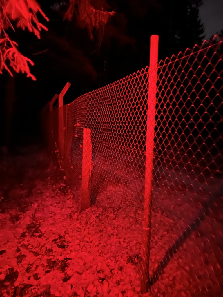 Ein Zaun im roten Taschenlampenlicjt